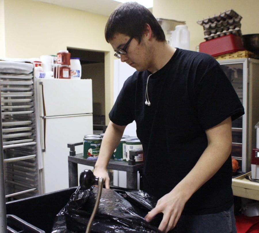 Senior Daniel Smith takes out the trash in the kitchen of Sharon Baptist Church | lauren sanders photo