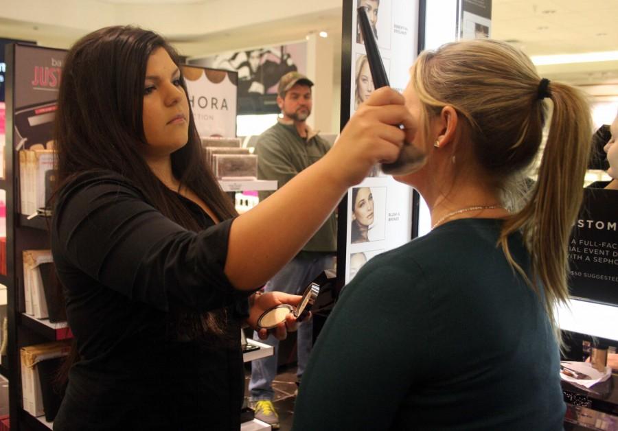 Senior Taylor Huff applies make-up to customer at Sephora. | lauren sanders photo