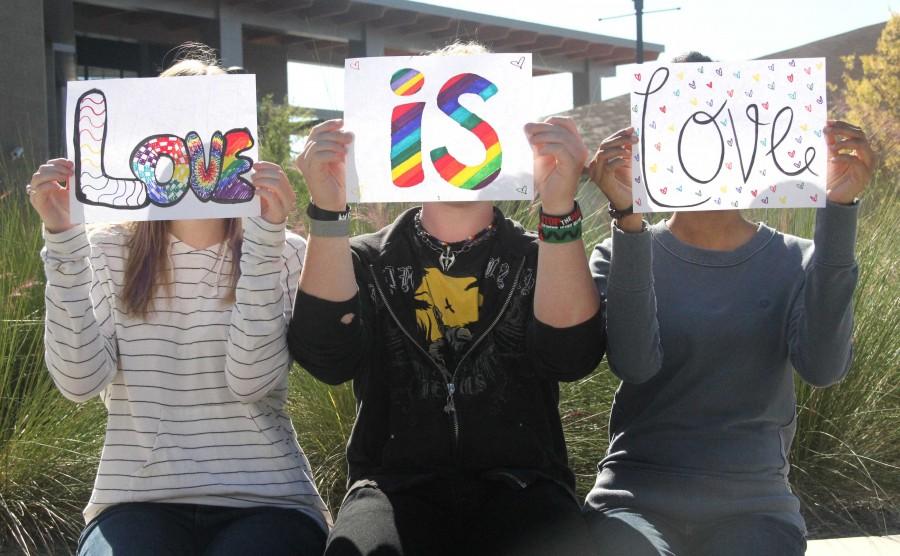To promote LGBT Awareness, junior Rachel Hacker, freshman John Hampton and junior Michelle Wallace hold signs reading Love is love over their face. | photo Paige Staggs