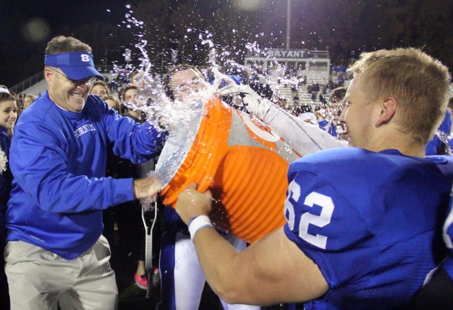 Seniors offensive linemen Josh Earls and Jacob Ward attempt to dumb the cooler on head coach Paul Calley after the teams 21-17 victory against El Dorado Nov. 8. The win clinched the 7A/6A South conference title and the second seed of the playoffs. 