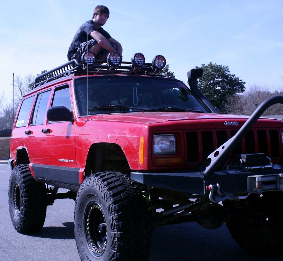 Sporting his off-road lights and stinger bar, senior Alec Zeiner drives a lifted red jeep Cherokee | Baylie McLaren photo 