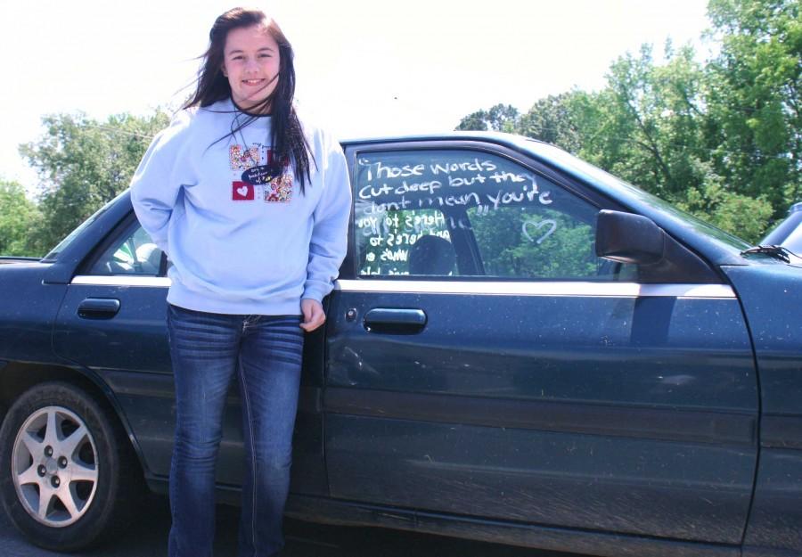 Junior Jamie Jamison stands in front the words that she painted on her car window to give hope to others. | photo emma barnes