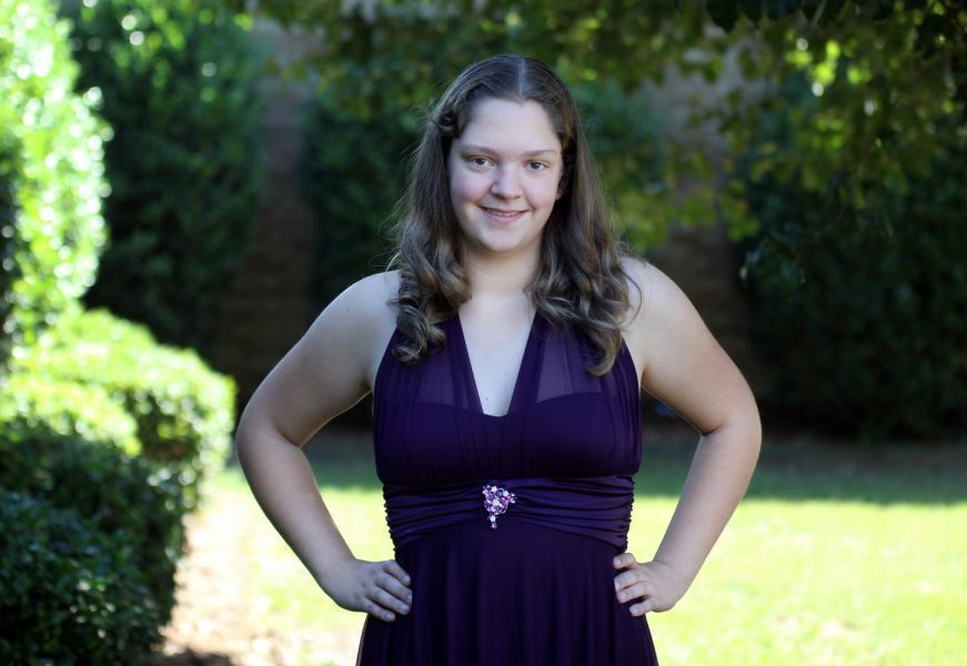 Freshman Kaitlynn Lilly poses in her homecoming dress. Lilly received the dress from the donations taken by Teachers of Tomorrow. Sophomore Callie McKim led the donations.