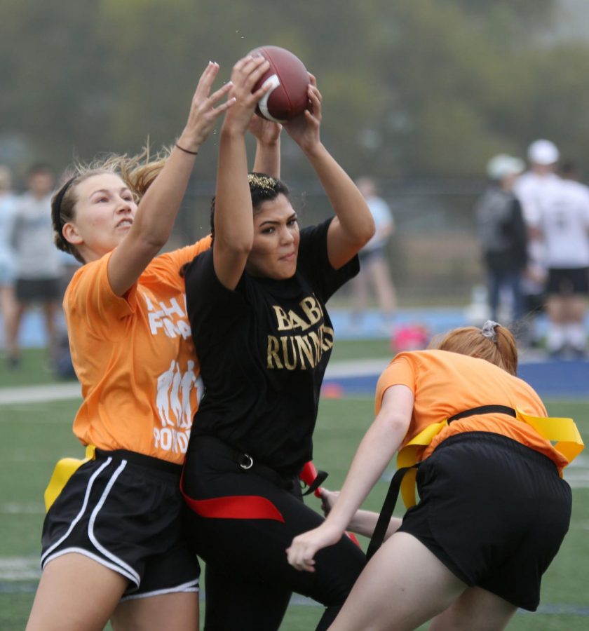 Senior Megan Quijano catches the ball while senior Hannah Fort tries to intercept it.