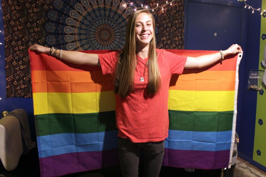 Senior Emily Clark holds up a pride flag.