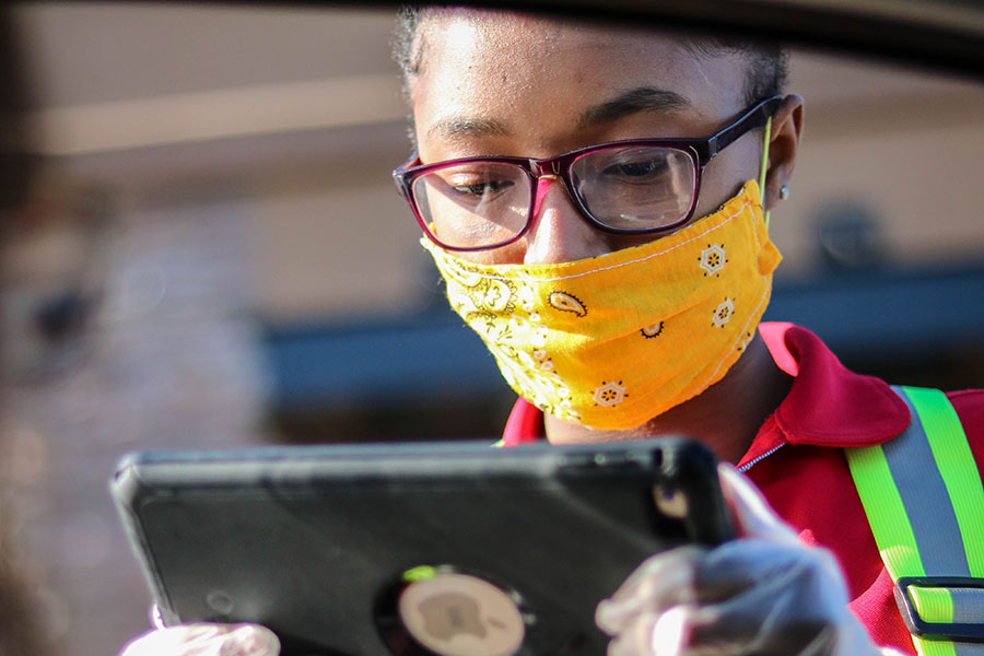 Taking an order, senior Jaedyn Lee works a shift at Chick-fil-A May 9. Although Lee chose to stay on campus, many students chose virtual learning to balance their classes with their work schedules.