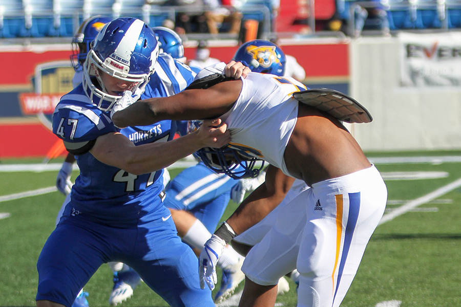 Trying to maintain his grip, senior middle linebacker Kevin Taylor tries to stop North Little Rock Wildcat #31 Justin Cole during the State Championship Dec. 5 at War Memorial Stadium. The Hornets won 27-17. This makes the third year in a row that the Bryant Hornets have won the 7A state finals. 