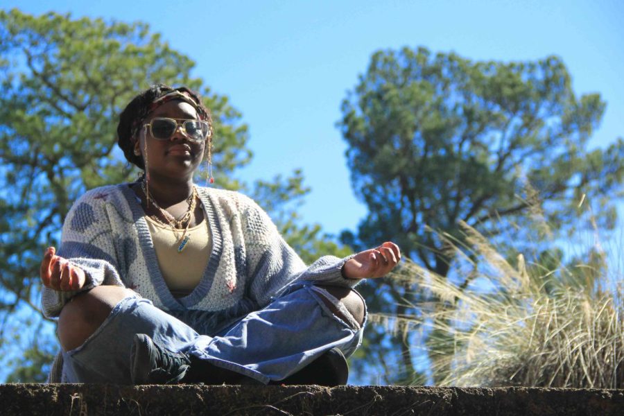 Junior Sage Williams meditates outside on the Bryant High School Campus.