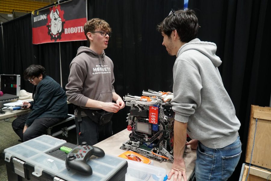 Senior Gavin Hill and Senior Alexander Spicer discuss and look over their robot during the state competition.