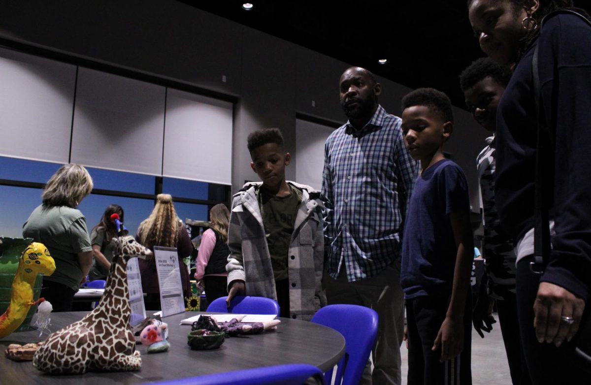 At the Preview Night for Bryant High School, a family looks at Art Club sculptures for the Art Classes.
