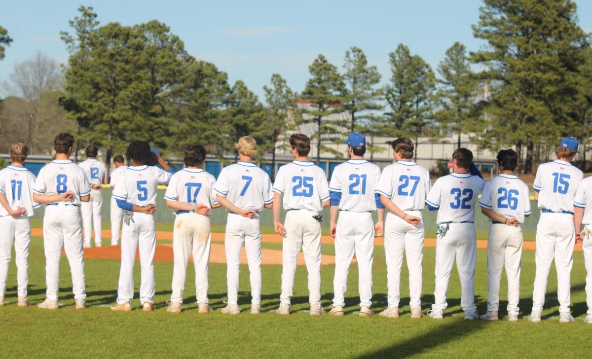 The boys Baseball team standing for the flag before their game against Jonesboro. 