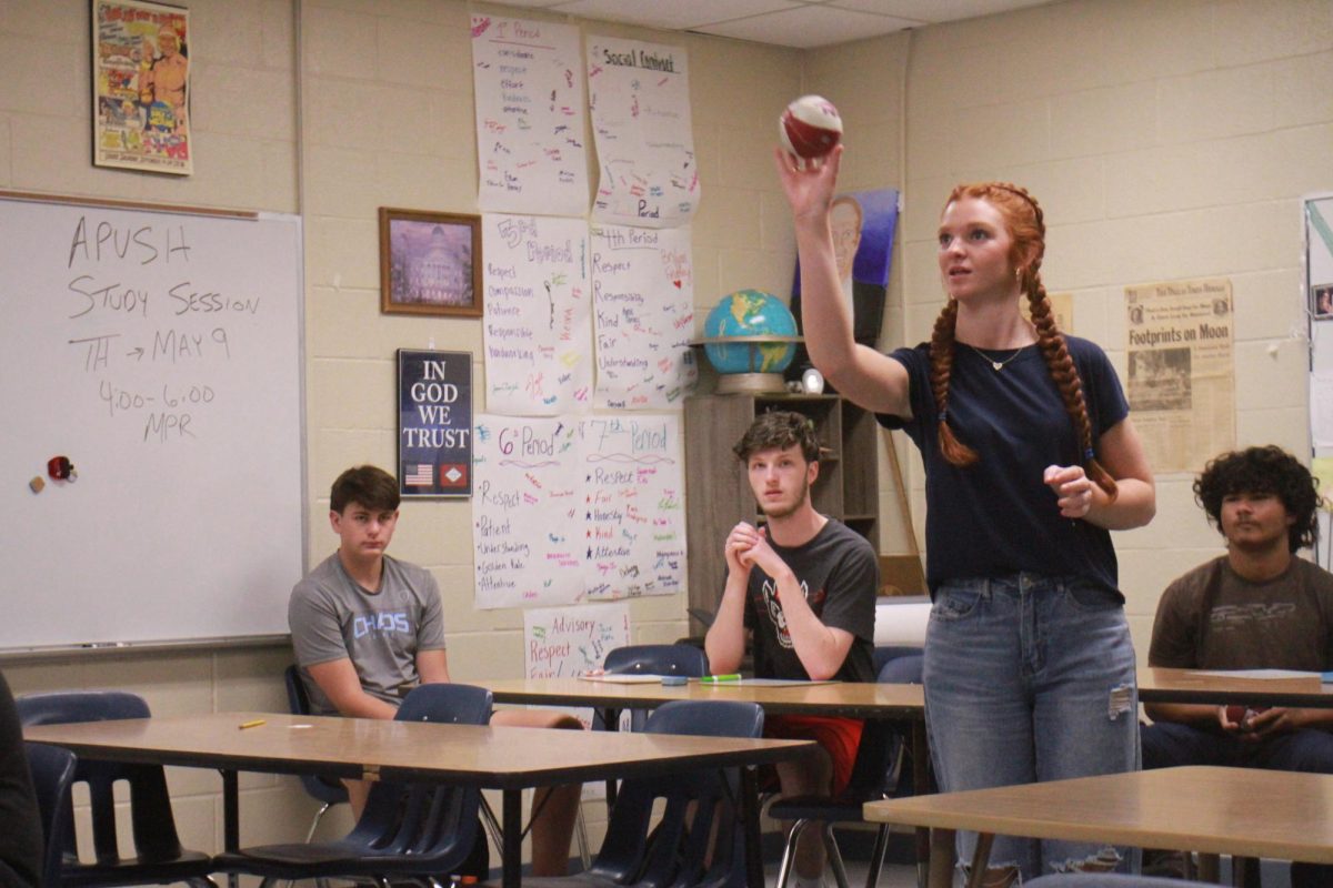 Junior Laci Baugh throws a ball into a basket to gain points for her team during a review game.