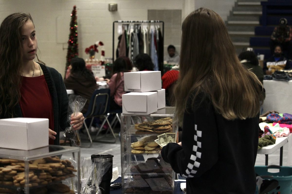 Sophomore Gabrielle Smith sells chocolate dipped cake pops to a Bryant student at her booth for a dollar each. She baked the treats herself, preparing for the event for as much as a week beforehand. 
“Not many people know I sell baked goods” Smith said.