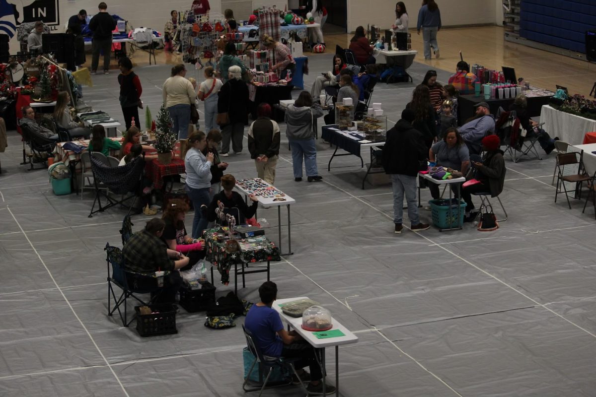 Vendors sell their merchandise from their booths, as shoppers gather and look at all the booths and purchase items. The Big Blue Market, held in the Building 1 Gym on Dec. 7, provided Bryant students the opportunity to sell their products to people in the community and their peers.
