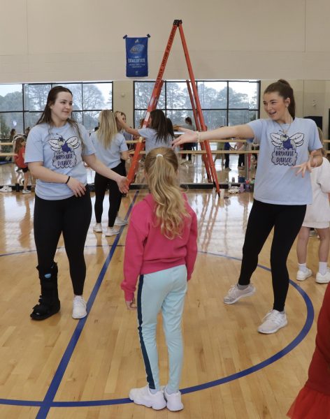 Juniors Hailey Johnson and Saylor Bradley dancing with an elementary student during a game of freeze dance on Jan.18.
