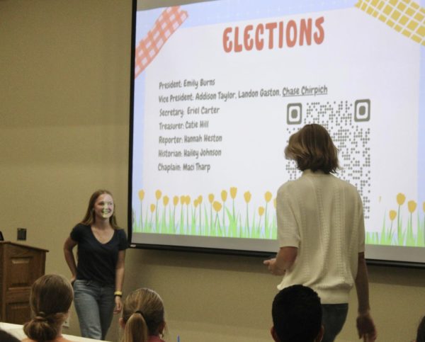 Reporter Addison Taylor steps away from the podium after announcing the beginning of officer elections during the final Beta Club Meeting of the 2024-2025 school year in the MPR. Chaplain Landon Gaston takes the floor to introduce the candidates.