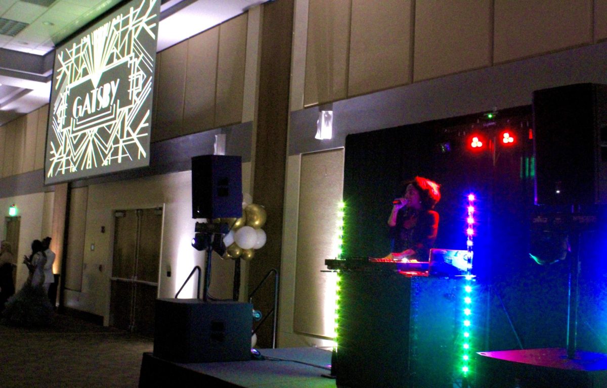 A DJ announces the beginning of the 2025 Great Gatsby Prom to attendees.
