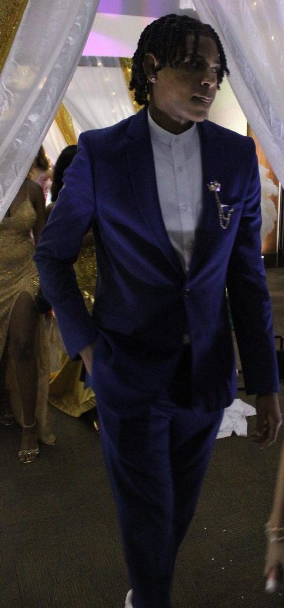 Attendees in formal attire walk through the front entrance of the 2025 Great Gatsby Prom at the Benton Event Center.