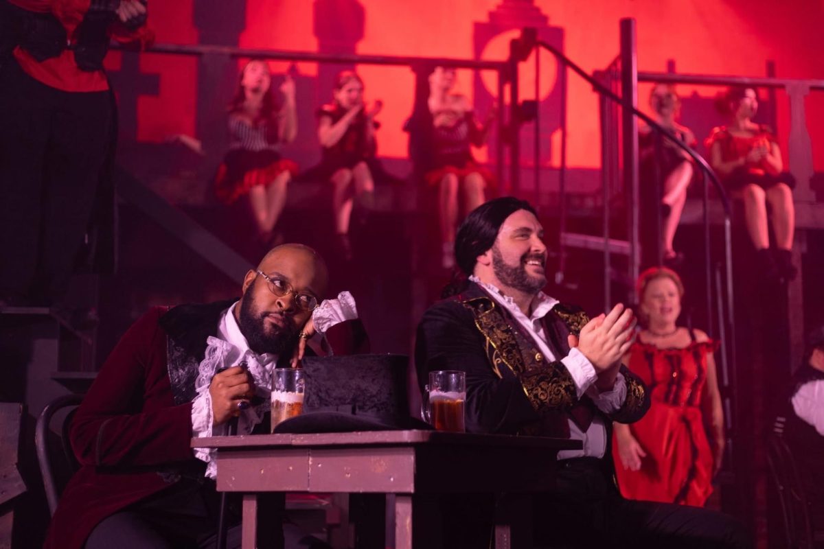 Sa’teh Hampton, portraying Utterson—Jekyll’s lawyer, indulges his client and friend, Rex Wilson—playing as Dr. Henry Jekyll, as he applauds for a performance at the Red Rat, a bar in the less respectable part of town.